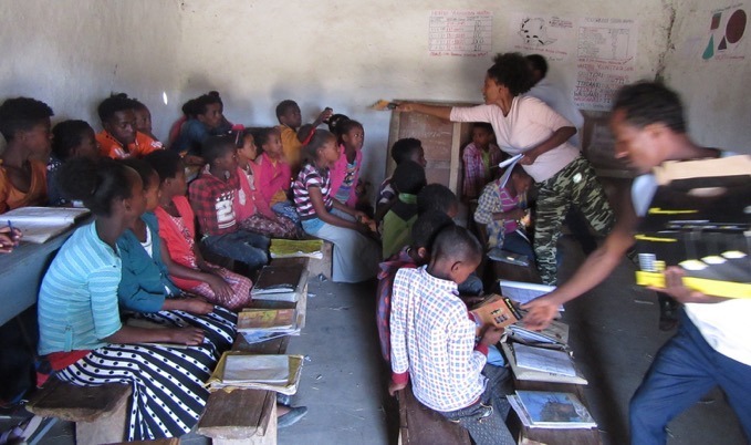 Green Scene founder demonstrating a solar light to a classroom of students at Abuserkema School