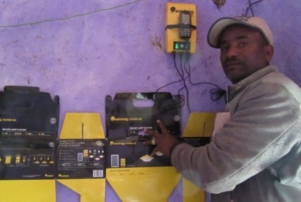 Shambel beside his newly installed solar home system