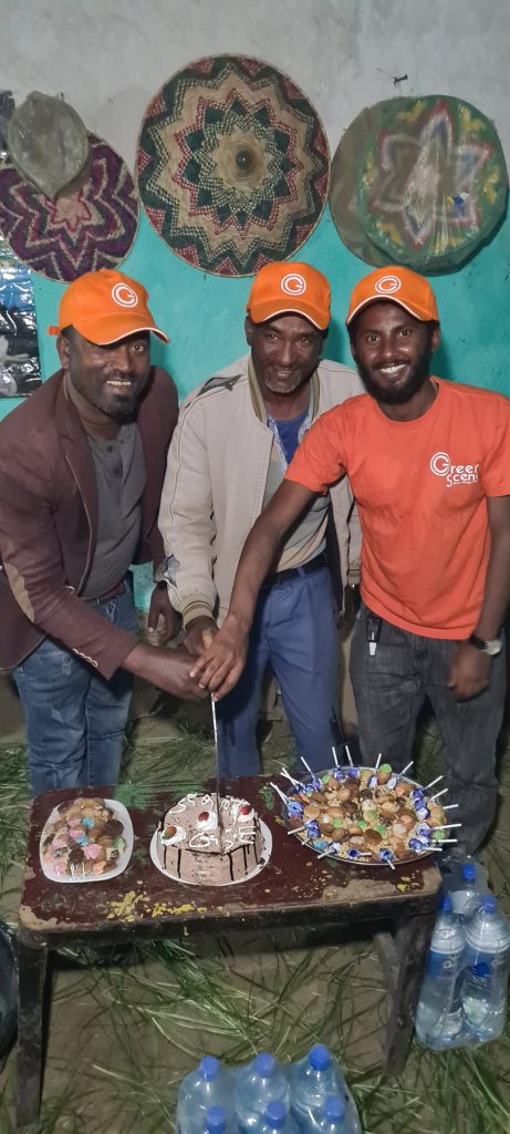 Green Scene team members in orange shirts beside the anniversary table