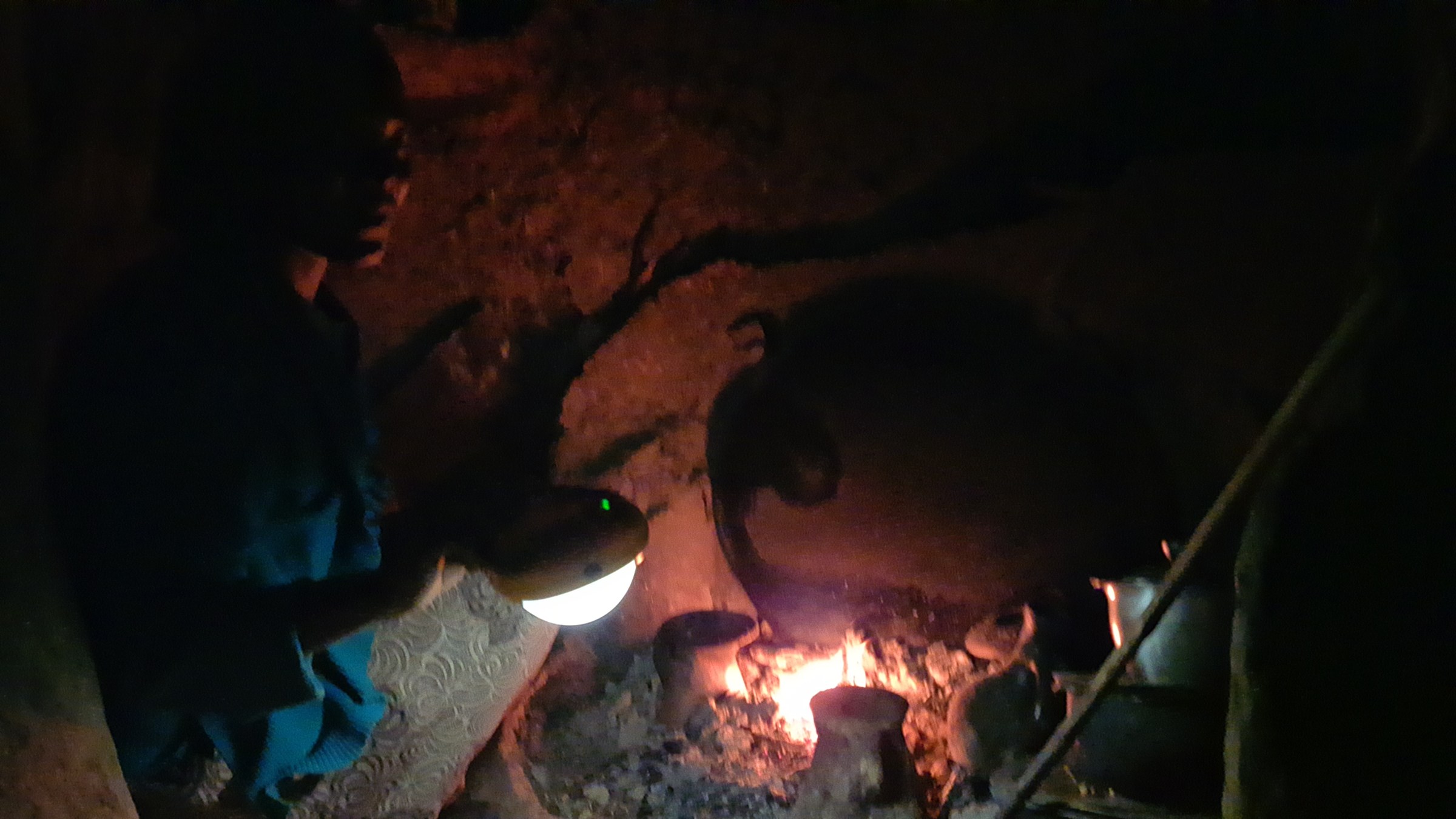 Woman cooking at night by solar lamp in Abuserkema, Ethiopia